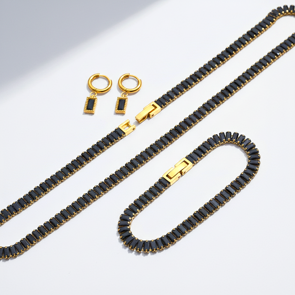 Jewelry set with black beaded necklace and earrings on a light gray background