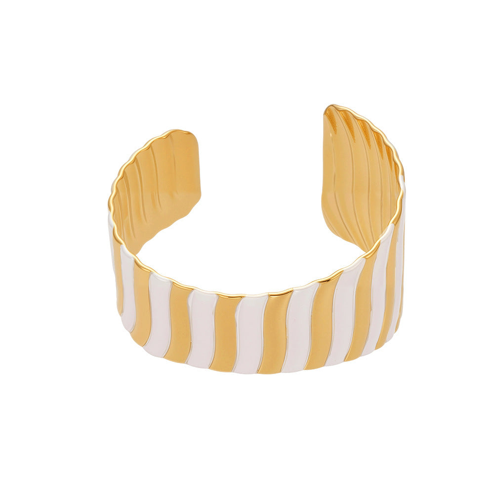 Yellow and white striped cuff bracelet on a white background
