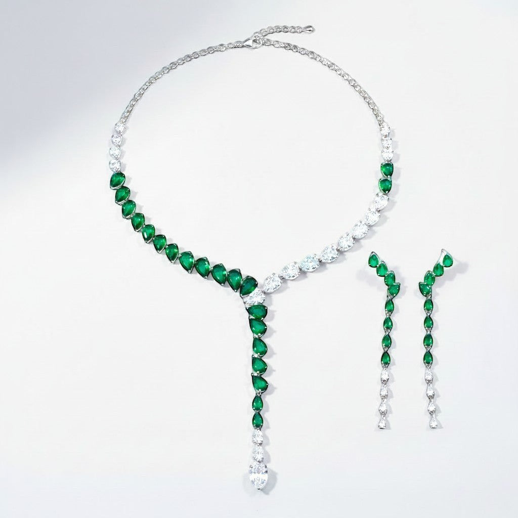 The Accessory Bar Doha set featuring a silver-tone necklace and drop earrings with emerald green pear-cut crystals.