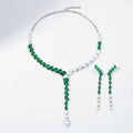 The Accessory Bar Doha set featuring a silver-tone necklace and drop earrings with emerald green pear-cut crystals.
