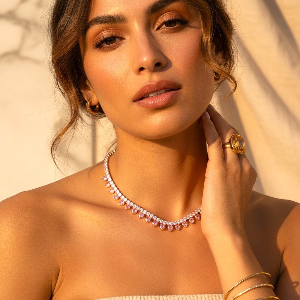 The Accessory Bar Hessa heart-detail tennis choker in gold-plated brass with pink cubic zirconia on a model