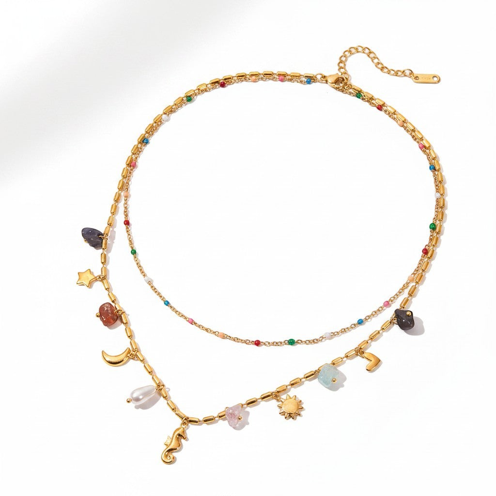The Accessory Bar layered gold chain necklace featuring colorful beads, charms, and a simulated pearl pendant.