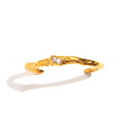 The Accessory Bar Lina gold-plated open cuff bracelet with a central baguette-cut white cubic zirconia stone.