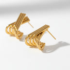 The Accessory Bar Lyra earrings featuring interlocking ribbed arcs in 18K gold-plated stainless steel.