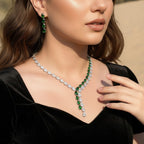 The Accessory Bar Nadia set featuring a silver-tone tennis necklace and matching drop earrings with emerald green stones.