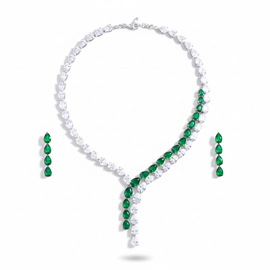 The Accessory Bar Nadia set featuring a silver-tone tennis necklace and matching drop earrings with emerald green stones.