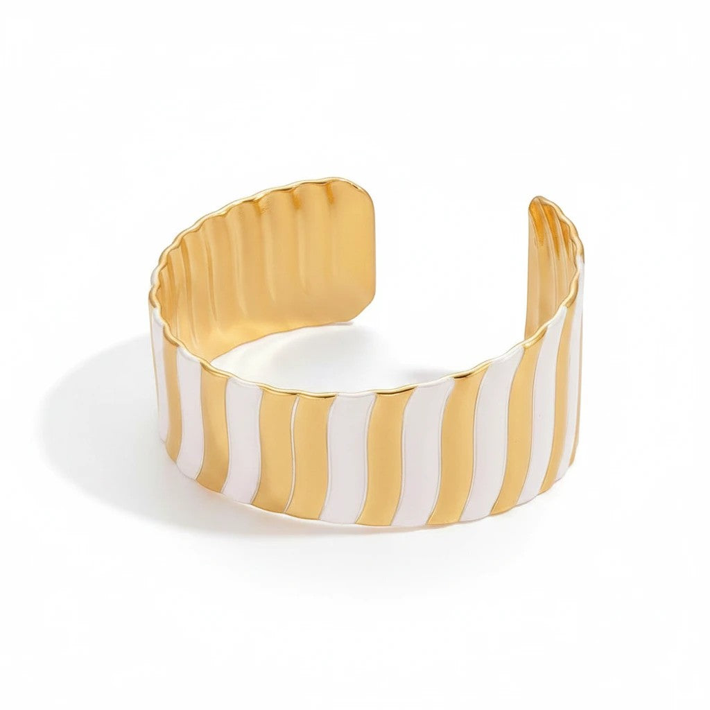 The Accessory Bar Sama wide open cuff bracelet featuring alternating high-polish 18K gold and silver ribbed stripes.